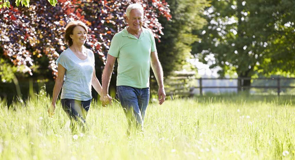 bigstock-Senior-Couple-Walking-In-Summe-94467596